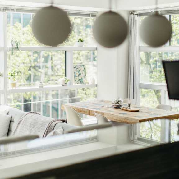 a modern dining area with a table and chairs by a large window.