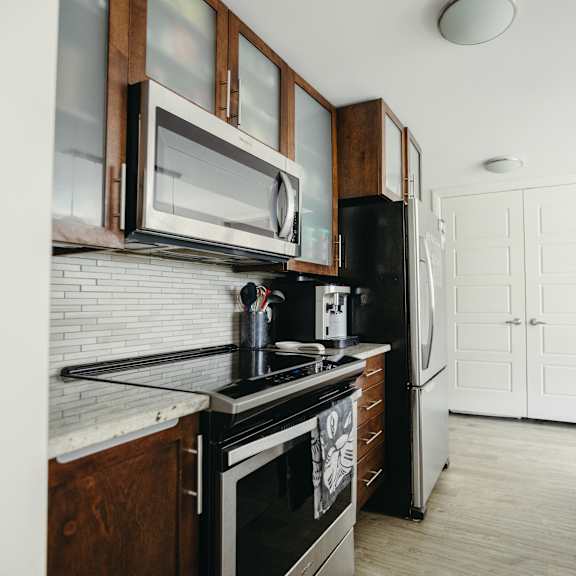 a kitchen with white cabinets and a black stove top oven.