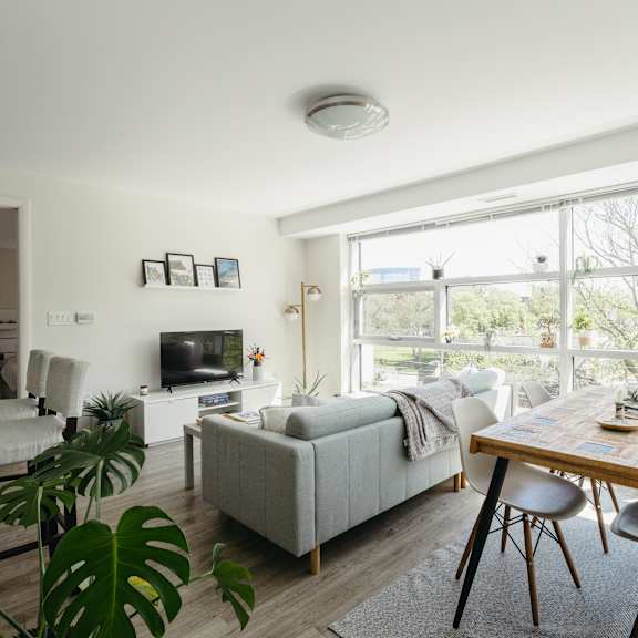 a living room with a couch, a chair, a table and a television.