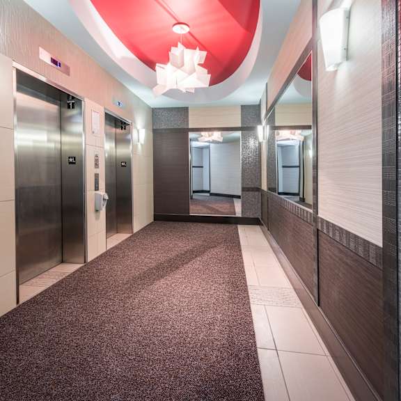 a long hallway with a red ceiling and a carpeted floor.