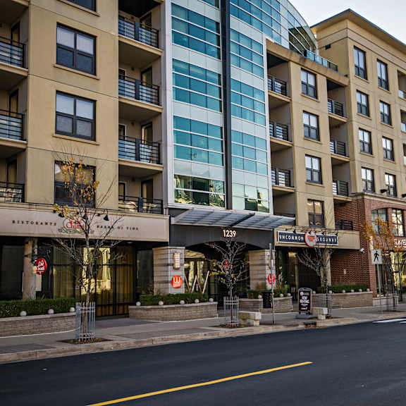 a street view of a building with a restaurant on the ground floor.