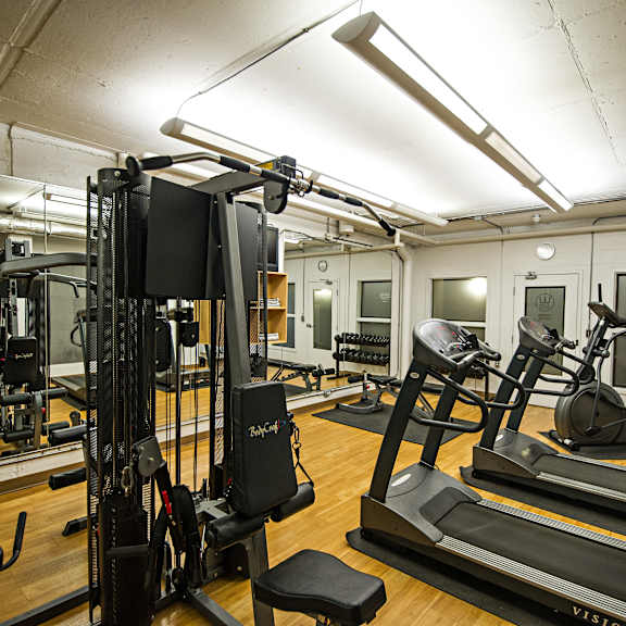 a gym with treadmills, weights and exercise equipment.
