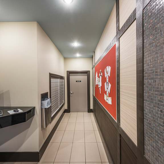 a hallway with a computer on a desk and a red poster on the wall.