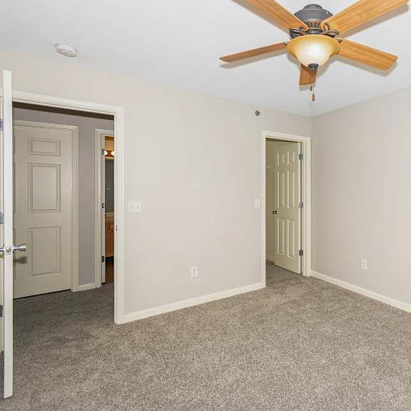 a room with a ceiling fan and carpeted floor.