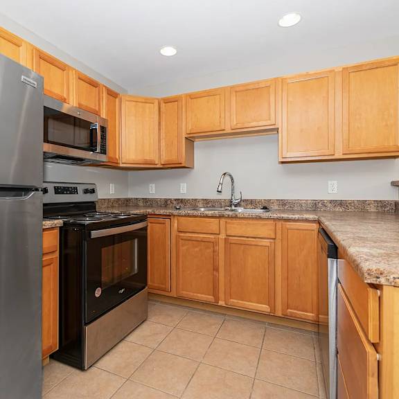 a kitchen with wooden cabinets and a granite countertop.