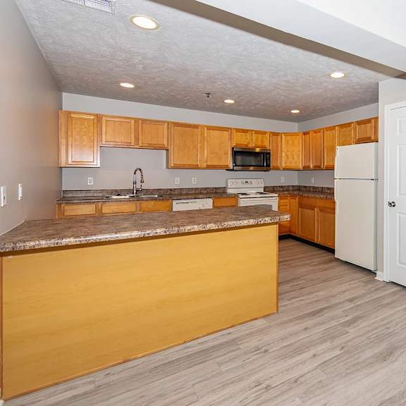 a kitchen with wooden cabinets and a white refrigerator.