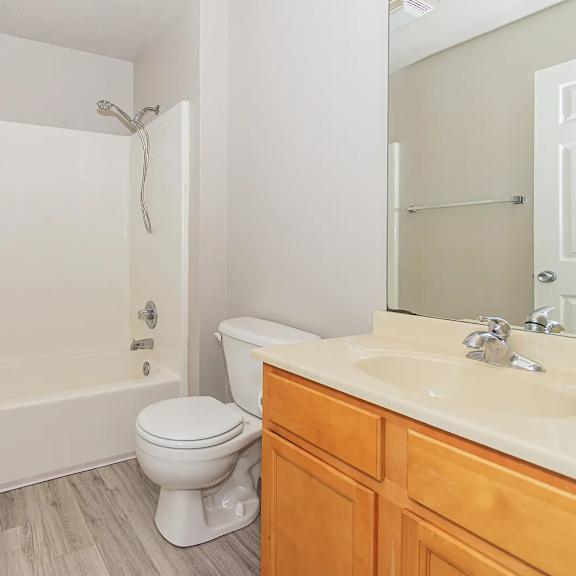 a white bathroom with a toilet, sink, and bathtub.