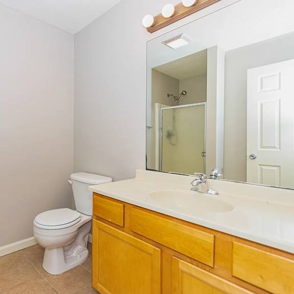 a white toilet sits in a bathroom next to a sink.
