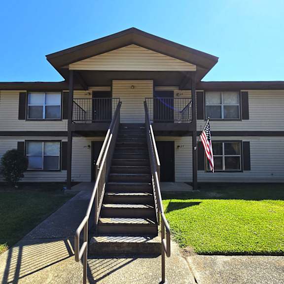 a house with a staircase leading to the front door.
