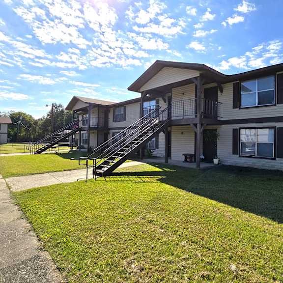 a two-story apartment building with a staircase leading to the second floor.