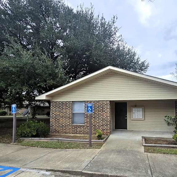 a small building with a parking sign in front of it.