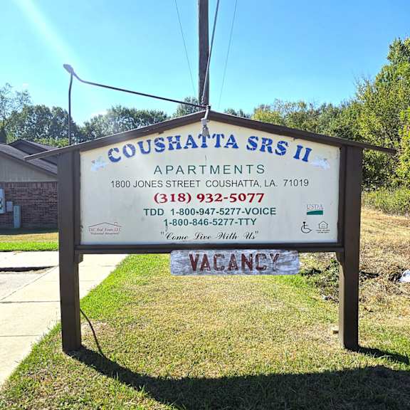 a sign for coushatta srs ii apartments with a vacancy notice.