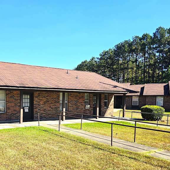 a house with a brown roof and a fence in front.