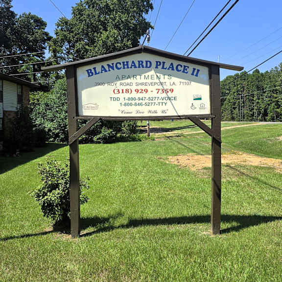 a sign for blanchard place ii apartments is shown in front of a grassy area.