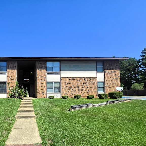 a brick building with a walkway leading to the front door.