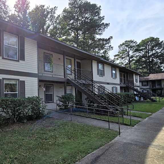a two-story apartment building with a staircase leading to the second floor.