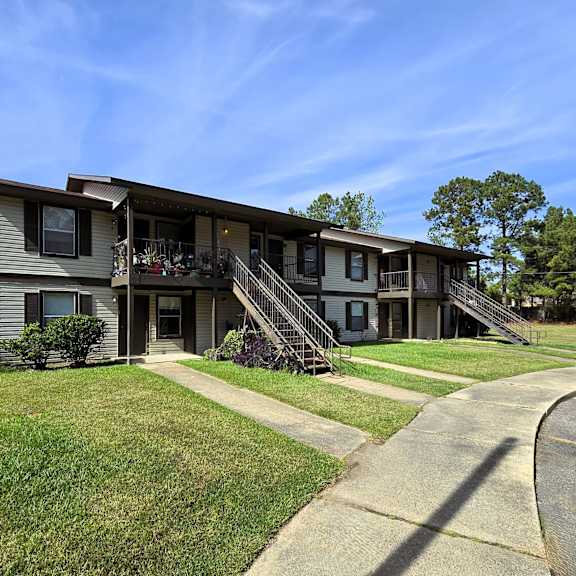 a residential building with a green lawn in front.