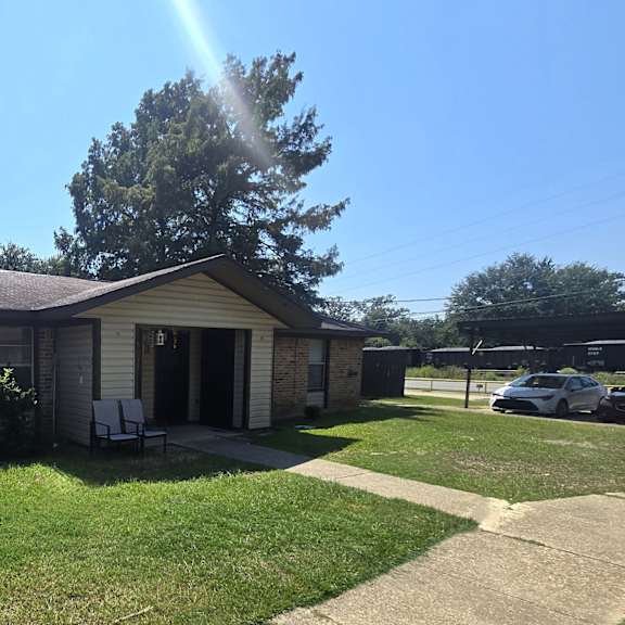 a house with a green lawn and a car parked in the driveway.