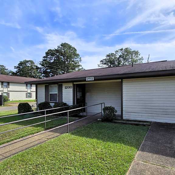 a residential building with a garage door and a metal railing.