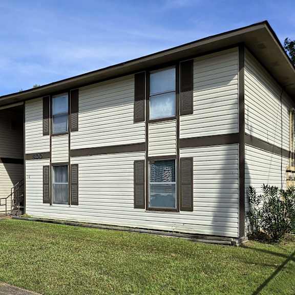 a two-story house with a grey siding exterior and a small front yard.