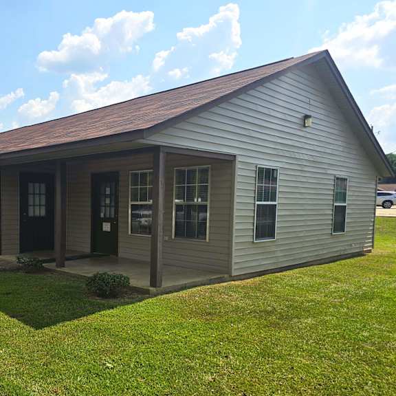 a small building with a brown roof and a grey exterior.