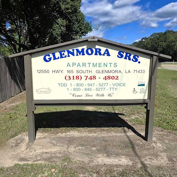 a sign for glenmora srs. apartments with contact information.
