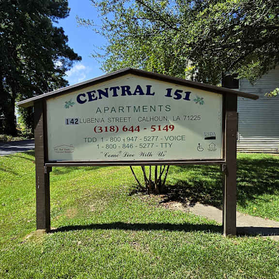 a sign for central isi apartments is displayed in front of a tree.