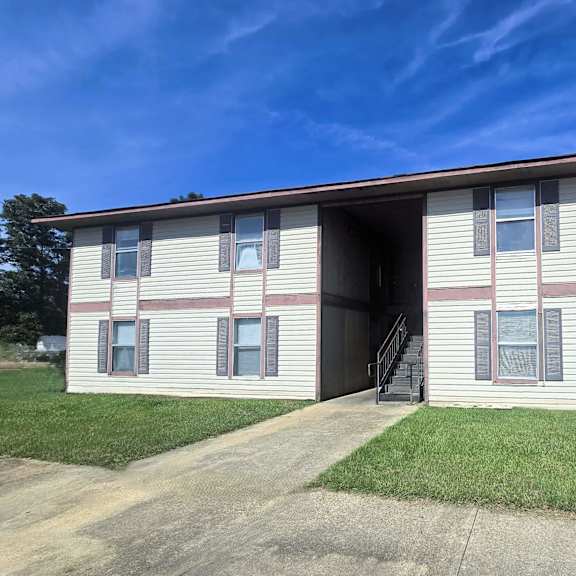 a two-story apartment building with a garage door open.