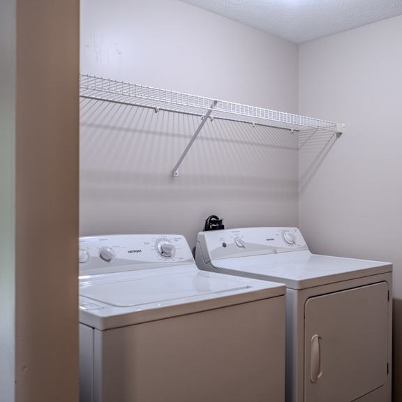 a white washing machine and dryer in a small laundry room.