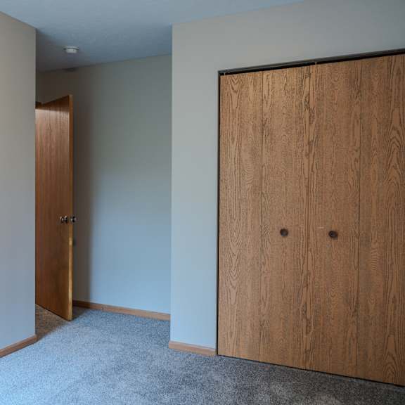 a room with a wooden door and a carpeted floor.