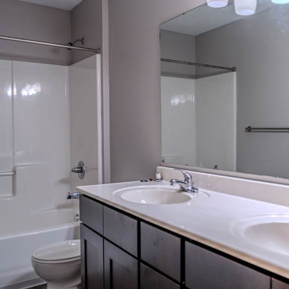 a bathroom with two sinks and a toilet.
