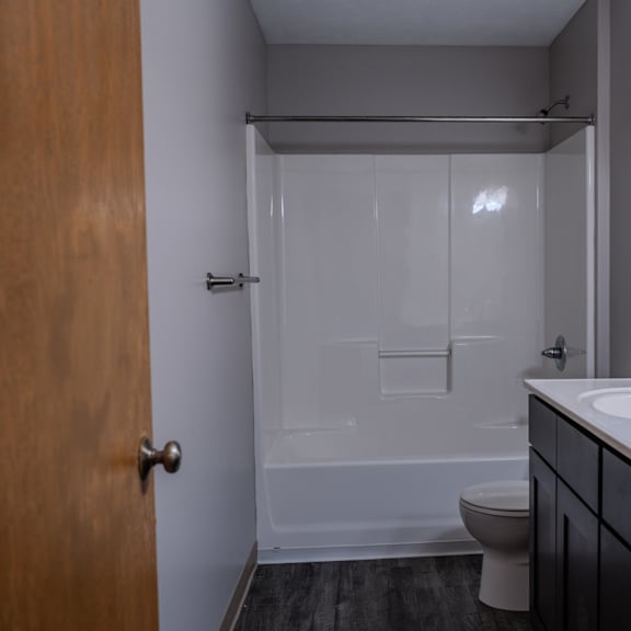 a bathroom with a toilet, sink, and shower.