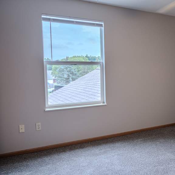 a room with a window overlooking a wooden deck.