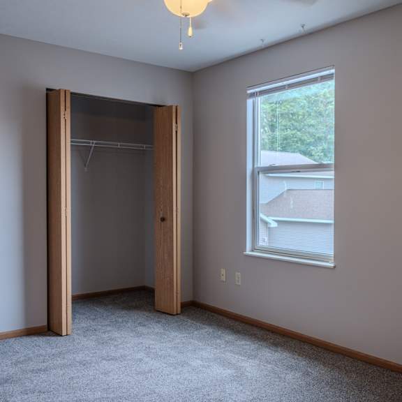 a room with a grey carpet and a window.
