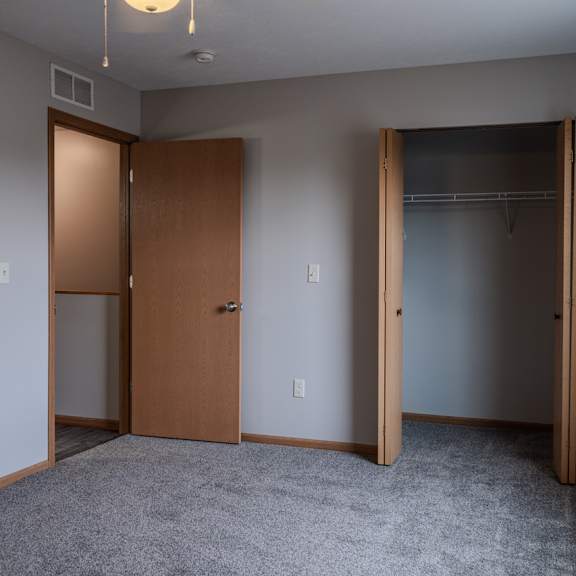 a room with a carpeted floor and two doors.