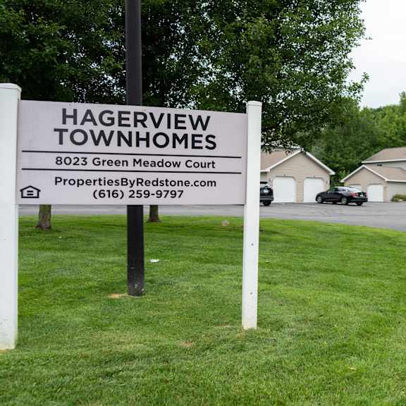 a sign for hagerview townhomes is displayed in front of a grassy area.
