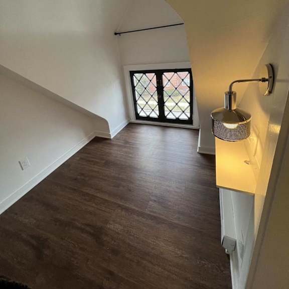 a long hallway with a window and a light on the wall.