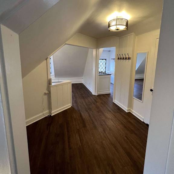 a hallway with wood floors and white walls.