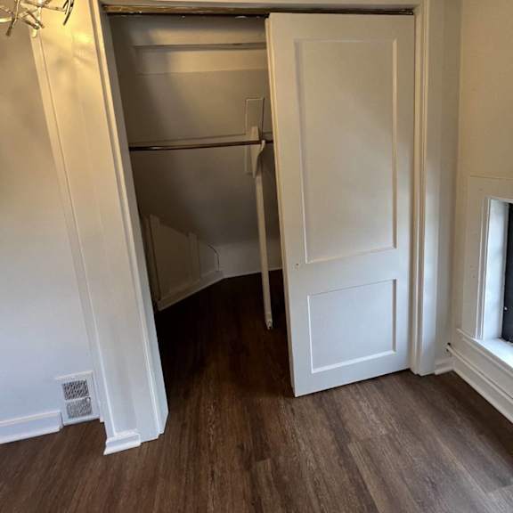 a white door is open to a small kitchen.