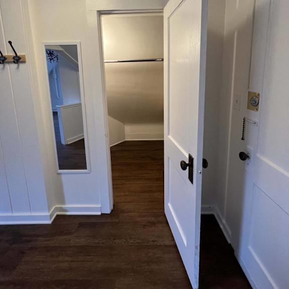 a white door is open to a hallway.
