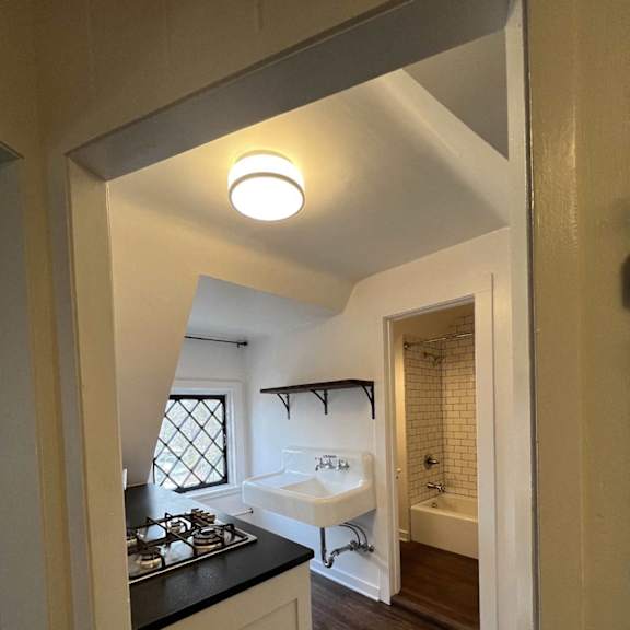 a small bathroom with a white sink and a window.