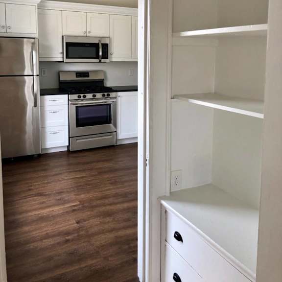 a kitchen with white cabinets and a stainless steel refrigerator.