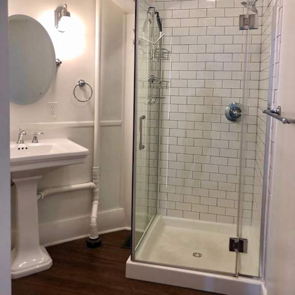 a white sink and a glass shower stall with a white tub.