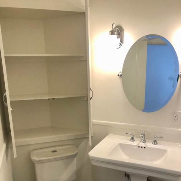 a white toilet with a white sink and a white cabinet.
