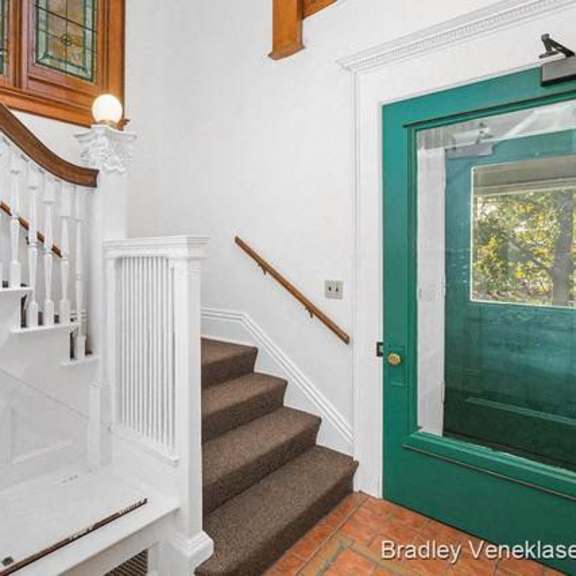a staircase with a green door at the bottom.