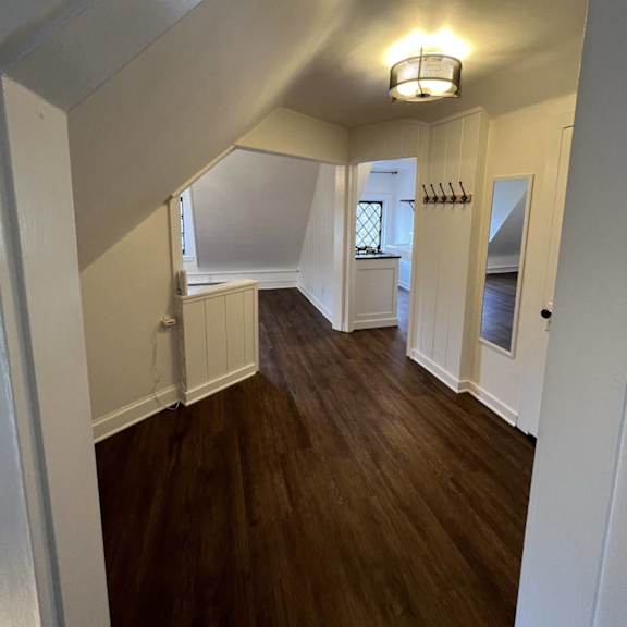 a hallway with wooden floors and white walls.