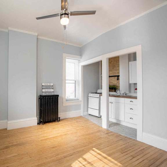 a room with a wood floor and a ceiling fan.