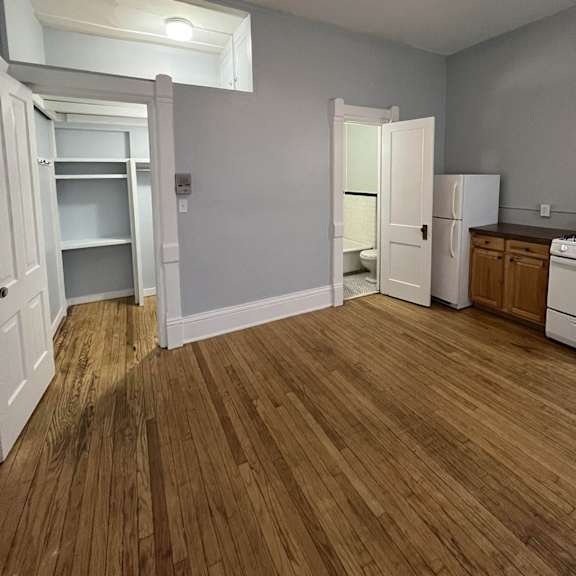 a room with a ceiling fan and wooden flooring.