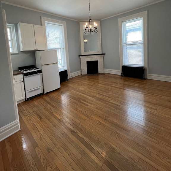 a kitchen with wooden floors and a chandelier.