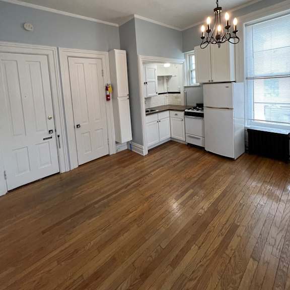 a kitchen with wooden floors and white cabinets.